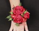 This elegant red corsage is beautiful with the hint of green, red roses and ribbon. This is great for any wedding or prom.