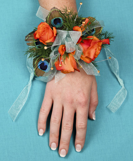 This prom corsage is great with the orange flowers and accents of peacock feathers and blue ribbon.