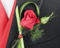 This red boutonniere features a single red rose with unique detailing of greenery.