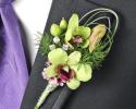 This green boutonniere features simple green flowers with unique greenery looping and crystal accents.