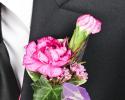 This colorful pink and purple prom boutonniere features a single pink flower with the accent of purple ribbon.  
