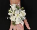 This beautiful white corsage is great for a wedding or prom. It features elegant white flowers with great details of pearls and greenery.