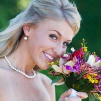 A wedding bouquet adds a pop of color when held against a traditional wedding dress. 